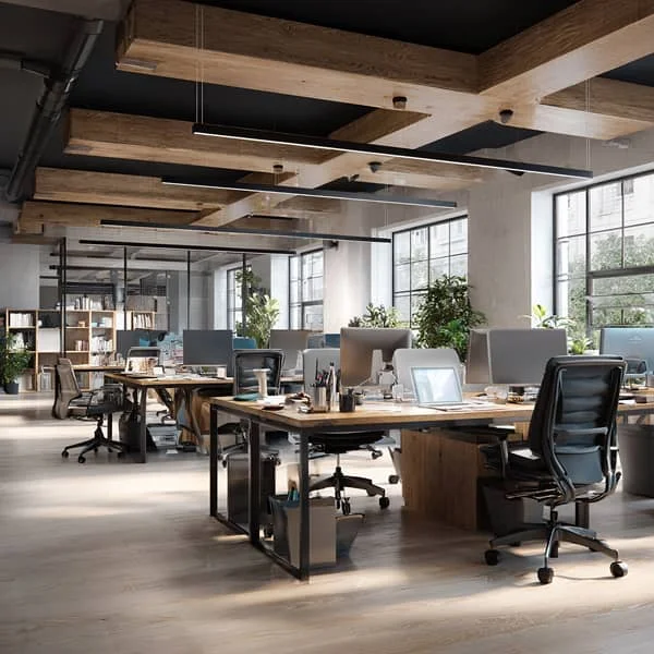 Grand bureau moderne en open space avec des postes de travail organisés, des chaises ergonomiques et une lumière naturelle abondante.