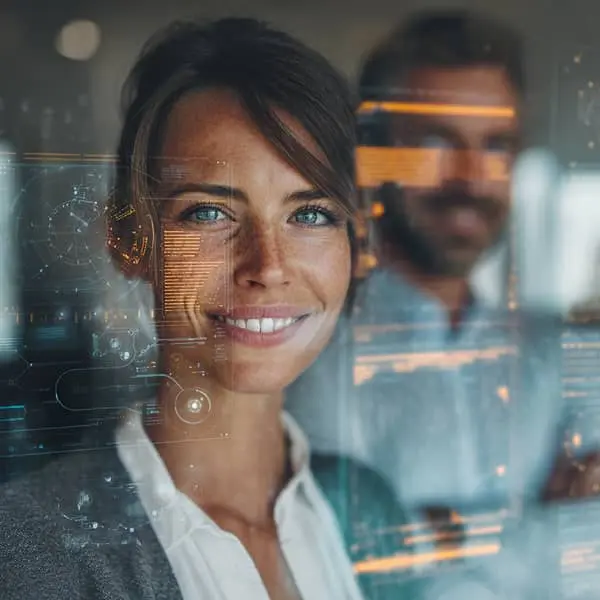 Portrait hyperréaliste d’une responsable RH souriante, face à une interface numérique transparente avec des données et éléments graphiques symbolisant l’intelligence artificielle, avec un collègue flou en arrière-plan.