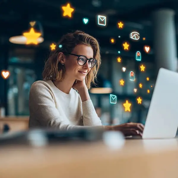 Responsable RH consultant des candidatures spontanées sur son ordinateur avec des icônes d’avis et d’attractivité symbolisant la marque employeur